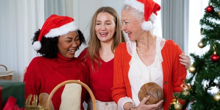 Elderly Woman in Santa Hat Laughing With Family in Independent Living