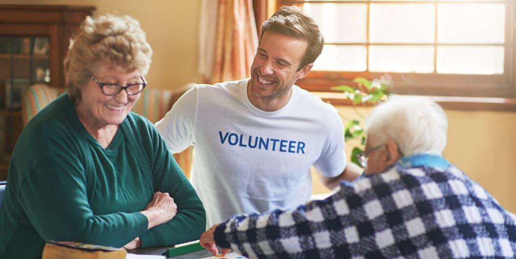 Male Volunteer Engaging with Elderly Residents at Independent Living Facility