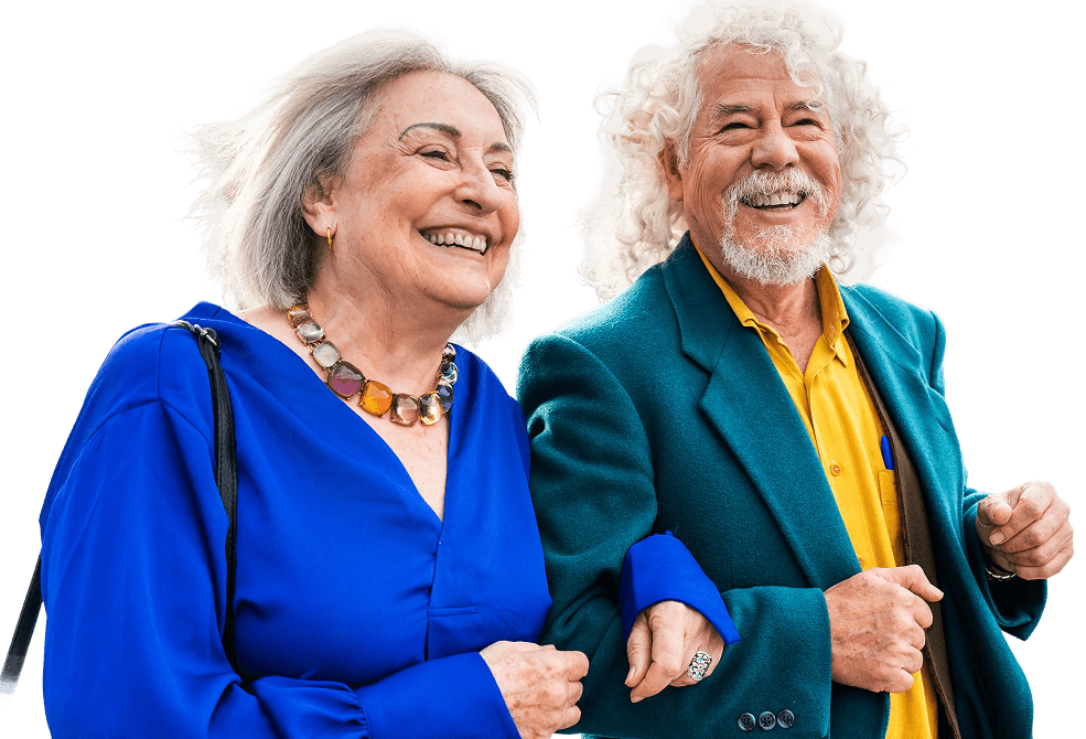Cheerful Elderly Couple in Bright Outfits Walking Arm in Arm at an Independent Living Facility Cheerful Elderly Couple in Bright Outfits Walking Arm in Arm at an Independent Living Facility