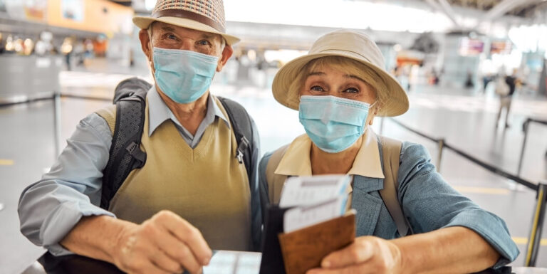 Elderly Couple Wearing Masks Holding Passports at the Airport from Independent Living Facility