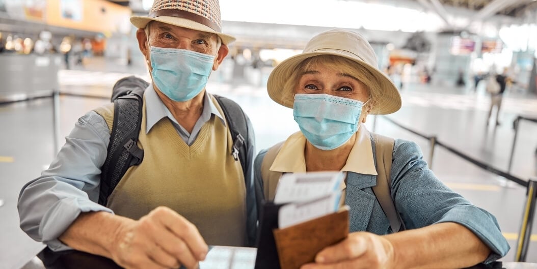 Elderly Couple Wearing Masks Holding Passports at the Airport from Independent Living Facility